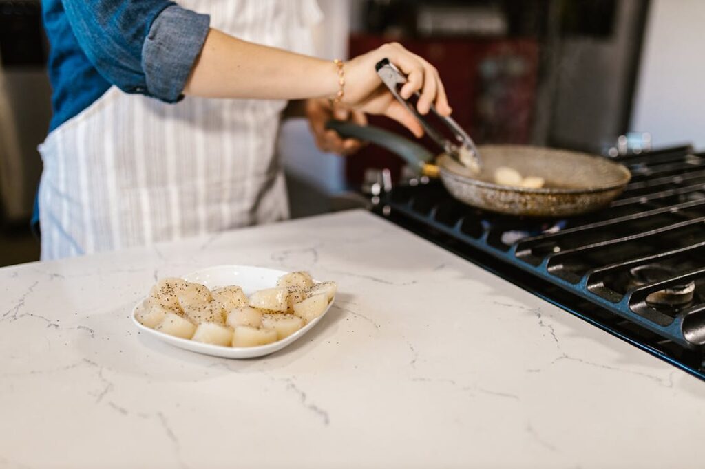 Woman preparing scallops in a pan 