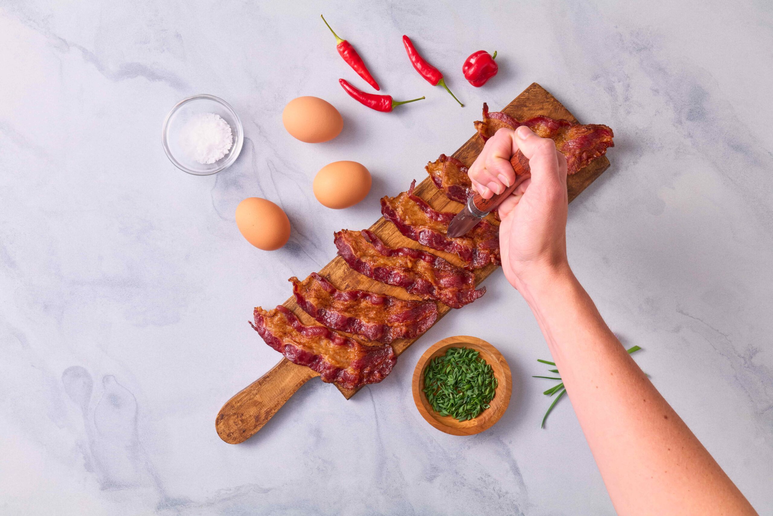 Bird's eye view of bacon on a wooden board for bacon cooking ideas