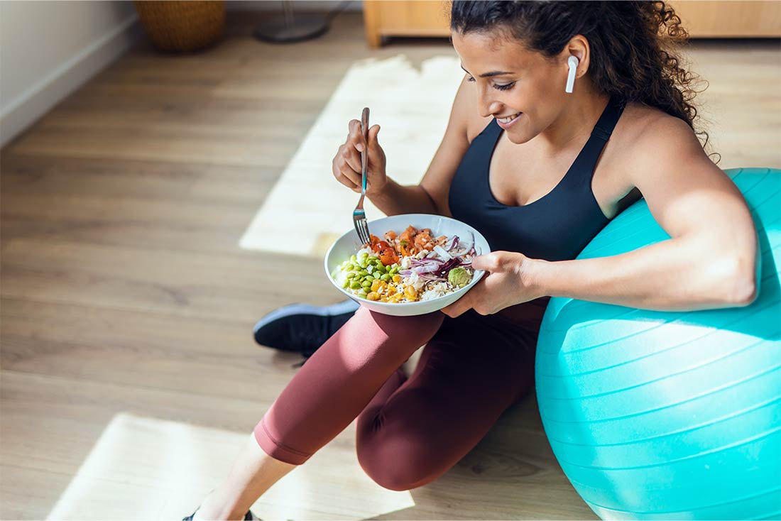 Image of person eating salad near medicine ball for blog about staying healthy