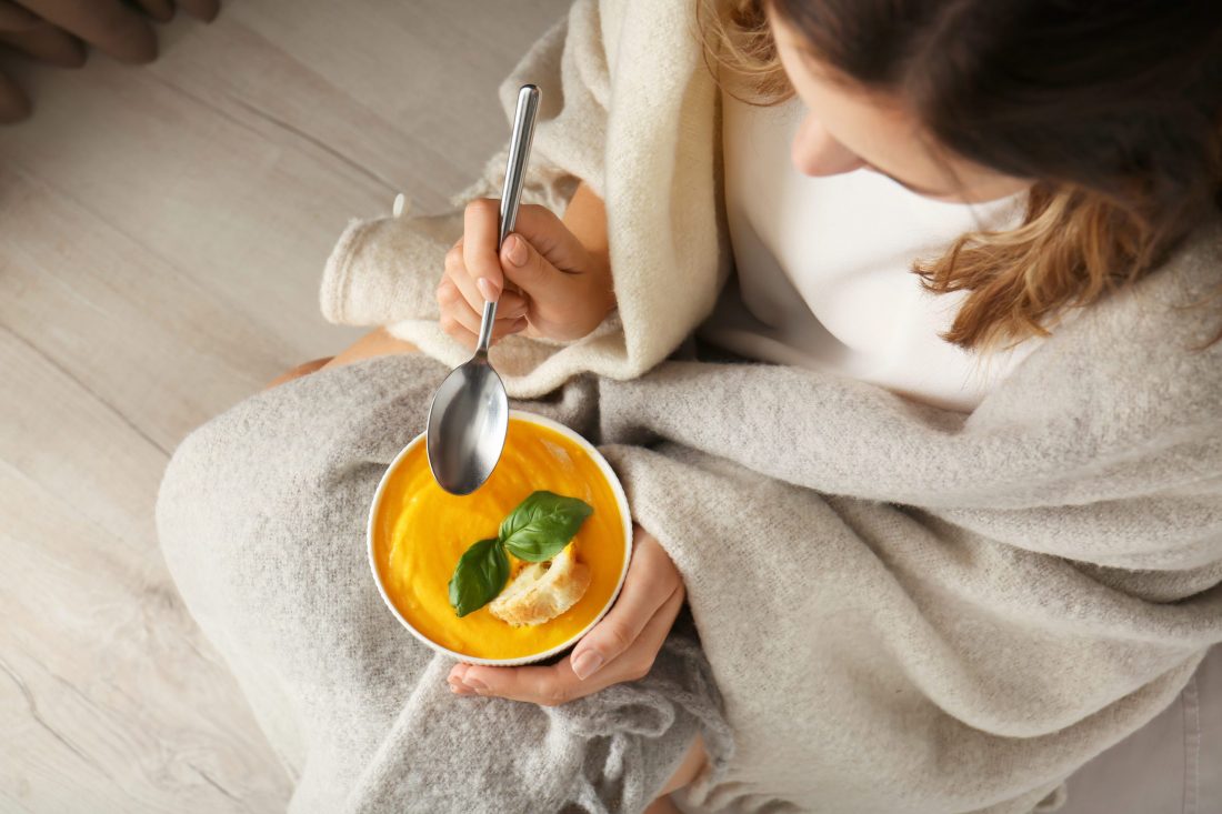 Bird's eye view of woman eating soup, used on blog titled 5 Meal Ideas to Keep You Warm
