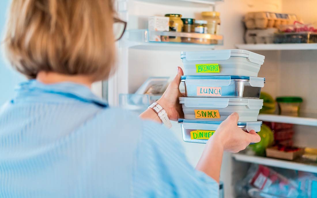 Image of woman taking food out of fridge, used on blog about bacon shelflife.