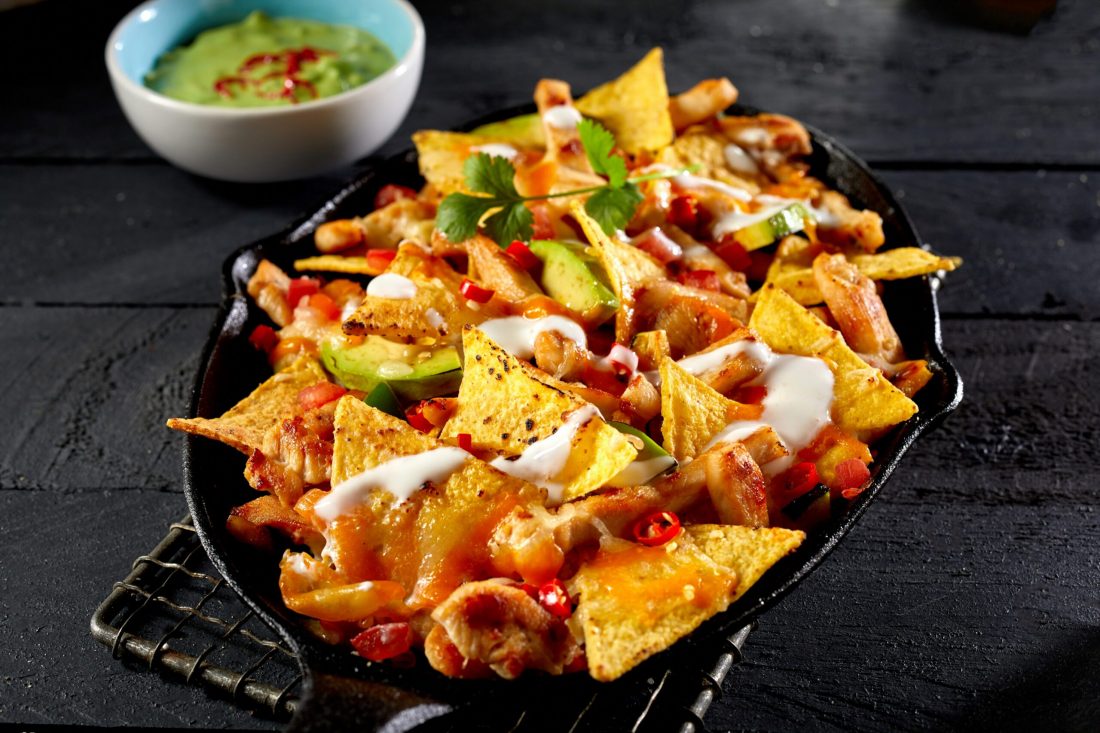 Chicken,Nacho,Tortilla,With,Cream,Sauce,Served,Next,To,Guacamole