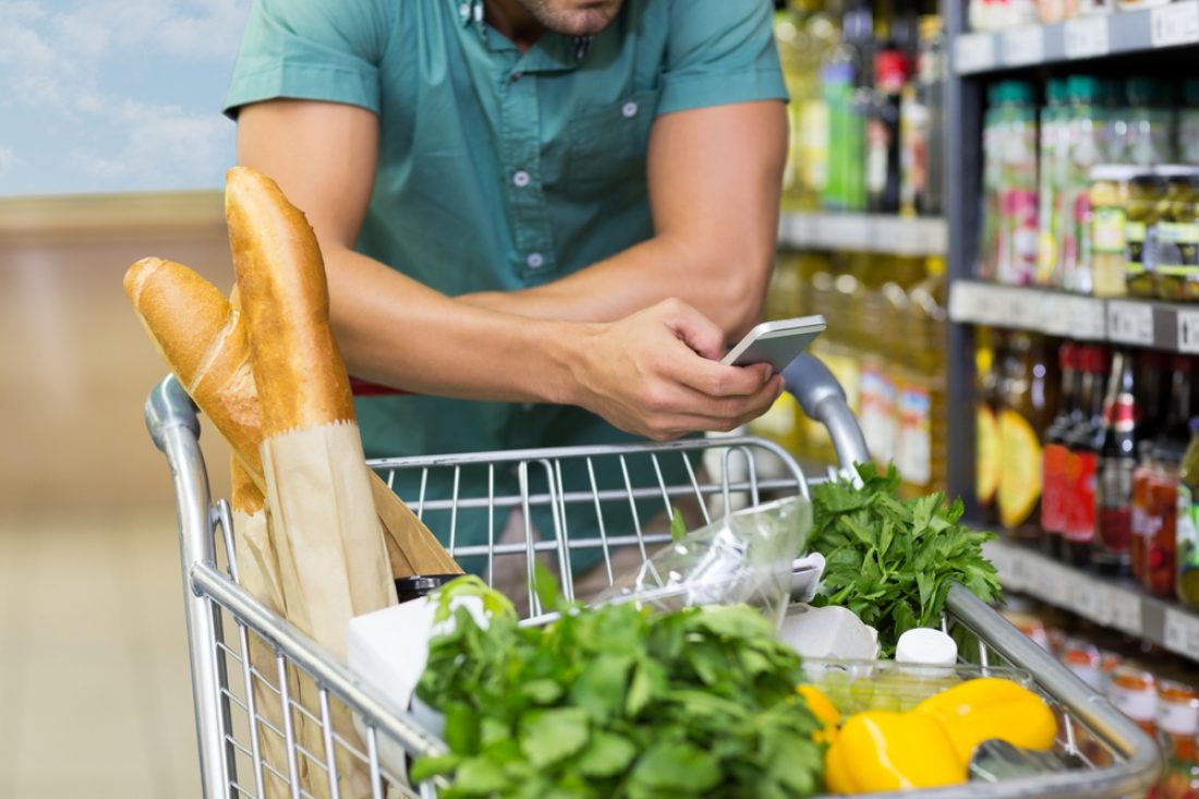 Man,Buy,Products,And,Using,His,Smartphone,At,Supermarket